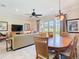 Comfortable dining area adjacent to the living room featuring an elegant chandelier and views of the golf course at 7409 Excitement Dr, Reunion, FL 34747