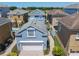 Lovely light blue home featuring a white garage door, well-manicured landscaping, and a paved driveway at 7409 Excitement Dr, Reunion, FL 34747