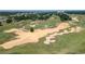 Scenic aerial view of a lush golf course with manicured greens, sand traps, and mature trees at 7409 Excitement Dr, Reunion, FL 34747