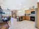 Open-concept kitchen with modern appliances, light wood cabinets, and a breakfast bar overlooking the living area at 7409 Excitement Dr, Reunion, FL 34747