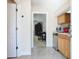 Compact kitchenette area with light wood cabinets, stainless steel appliances, and a passthrough to an office area at 7409 Excitement Dr, Reunion, FL 34747