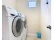 Laundry room with modern white front-loading washer and dryer, plus tiled flooring at 7409 Excitement Dr, Reunion, FL 34747