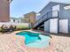 Outdoor kidney-shaped pool with brick pavers, lush greenery, and a black stair case at 7409 Excitement Dr, Reunion, FL 34747