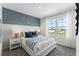 This bedroom has a blue accent wall, white furniture, and a beautiful view from the window at 756 Mocking Jay Ln, St Cloud, FL 34771