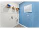 Laundry room with shelving and bright blue wall at 756 Mocking Jay Ln, St Cloud, FL 34771