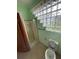 Bathroom featuring a shower and toilet, lit by a glass block window at 8129 Granada Blvd, Orlando, FL 32836