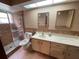 Well-lit bathroom features a glass shower, vanity, two mirrors and neutral tile at 8129 Granada Blvd, Orlando, FL 32836