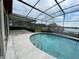Screened pool with an elegant shape and steps leading into the refreshing water, lake in the background at 8129 Granada Blvd, Orlando, FL 32836
