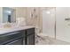 This bathroom features a single vanity with black cabinetry and a glass-enclosed shower with a white tile surround at 8844 Cabot Cliffs Dr, Davenport, FL 33896