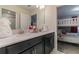 This bathroom features a double vanity with black cabinetry, white countertops and a peek into the bunk bed room at 8844 Cabot Cliffs Dr, Davenport, FL 33896