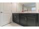 Modern bathroom vanity with double sinks, black cabinets, and a large mirror at 8844 Cabot Cliffs Dr, Davenport, FL 33896