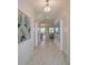 Bright hallway with tile flooring and contemporary art; glimpses of open living areas at 8844 Cabot Cliffs Dr, Davenport, FL 33896