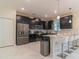 Modern kitchen featuring dark cabinetry, stainless steel appliances, and breakfast bar at 8844 Cabot Cliffs Dr, Davenport, FL 33896