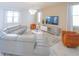 Bright living room featuring modern gray couches, orange accent chairs, and a contemporary chandelier at 8844 Cabot Cliffs Dr, Davenport, FL 33896