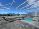 This screened-in pool area features a hot tub and two lounge chairs for ultimate relaxation at 8844 Cabot Cliffs Dr, Davenport, FL 33896