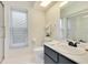 Well-lit bathroom with a single sink vanity, white tile floor, and shower at 9143 San Ambrosio, Orlando, FL 32836