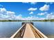 Long wooden dock extending into a pristine lake offers a place to enjoy the view at 9143 San Ambrosio, Orlando, FL 32836