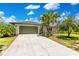 Charming single-story home with a green garage door, lush landscaping, and mature palm trees at 9143 San Ambrosio, Orlando, FL 32836