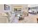 Open concept living room boasts a large sectional sofa, area rug, and view to the kitchen at 9143 San Ambrosio, Orlando, FL 32836