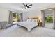 Comfortable main bedroom with a wooden bed frame, ceiling fan, and bright windows at 9143 San Ambrosio, Orlando, FL 32836