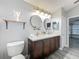 Bathroom featuring a double sink vanity, wood-look tile flooring, and a view into the water closet at 998 Piedmont Oaks Dr, Apopka, FL 32703