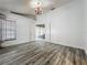 Bright bedroom with wood-look tile, ceiling fan, and double-door entry to living areas at 998 Piedmont Oaks Dr, Apopka, FL 32703