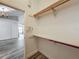 A well organized walk-in closet with wood shelving and wood-look flooring with a partial view of an adjacent room at 998 Piedmont Oaks Dr, Apopka, FL 32703
