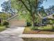 Charming single-story home with a well-manicured lawn, mature trees, and a beige two-car garage at 998 Piedmont Oaks Dr, Apopka, FL 32703