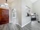 The foyer features a dark wood door, hardwood floors, arched doorway and view to the kitchen and living area at 998 Piedmont Oaks Dr, Apopka, FL 32703