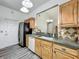 Kitchen featuring stainless steel refrigerator, tile backsplash, wooden cabinets, white dishwasher and door access at 998 Piedmont Oaks Dr, Apopka, FL 32703