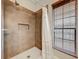 Walk-in shower with brown tiled walls, white mosaic tile flooring, and a window with wooden blinds at 998 Piedmont Oaks Dr, Apopka, FL 32703