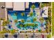 Aerial view of a resort pool with lounge chairs, umbrellas, palm trees, a playground, and parking at 10436 Ebb Tide Lane, Orlando, FL 32821