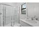 Clean bathroom featuring a glass-enclosed shower, white fixtures, and a well-lit vanity area, with a window at 10436 Ebb Tide Lane, Orlando, FL 32821