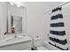 Bright bathroom with a tub, shower with a blue and white striped curtain, and a modern vanity with ample counter space at 10436 Ebb Tide Lane, Orlando, FL 32821