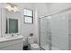 Clean bathroom featuring a glass-enclosed shower, white fixtures, and a well-lit vanity area, with a window at 10436 Ebb Tide Lane, Orlando, FL 32821