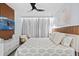 Stylish bedroom features a wood headboard, a modern ceiling fan, a flatscreen TV, pendant lighting, and bright natural light at 10436 Ebb Tide Lane, Orlando, FL 32821