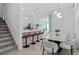 Bright dining area features a modern table, stylish chairs, and a view of the open kitchen with barstool seating at 10436 Ebb Tide Lane, Orlando, FL 32821