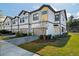 Modern townhome showcasing a two-car garage, neutral paint, and a well manicured lawn at 10436 Ebb Tide Lane, Orlando, FL 32821