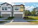 Modern townhome showcasing a two-car garage, neutral paint, and a meticulously designed exterior at 10436 Ebb Tide Lane, Orlando, FL 32821