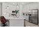 Bright, modern kitchen with stainless steel appliances and a large island featuring barstool seating and tiled backsplash at 10436 Ebb Tide Lane, Orlando, FL 32821