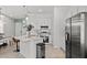 Modern kitchen with stainless steel appliances, white cabinetry, and a breakfast bar that connects to the dining area at 10436 Ebb Tide Lane, Orlando, FL 32821