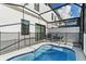 Screened-in pool area with safety fence, table, chairs, and grill at 10436 Ebb Tide Lane, Orlando, FL 32821