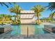 A close up view shows a resort pool with a waterfall feature, several lounge chairs, and mature palm trees at 10436 Ebb Tide Lane, Orlando, FL 32821