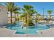 This inviting resort pool is surrounded by lounge chairs, umbrellas, palm trees, and neighborhood townhomes at 10436 Ebb Tide Lane, Orlando, FL 32821