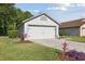 Attached two-car garage featuring a well-maintained lawn and tasteful landscaping details at 1118 Brielle Ct, Oviedo, FL 32765