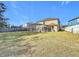 Expansive backyard showcasing the home's exterior, a large lawn, and a screened-in pool area with a spa at 1176 Liberty Hall Dr, Kissimmee, FL 34746
