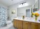 Well-lit bathroom with a double sink vanity, marble countertop, and shower-tub combo at 1176 Liberty Hall Dr, Kissimmee, FL 34746