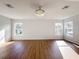 Bright bedroom features wood-look floors, a modern light fixture, and sunlit windows at 1176 Liberty Hall Dr, Kissimmee, FL 34746