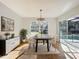 Bright dining room with a modern table, chandelier, and sliding glass doors to the pool area at 1176 Liberty Hall Dr, Kissimmee, FL 34746