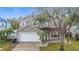 Charming two-story home with a well-maintained lawn, a two-car garage, and lush landscaping at 1176 Liberty Hall Dr, Kissimmee, FL 34746